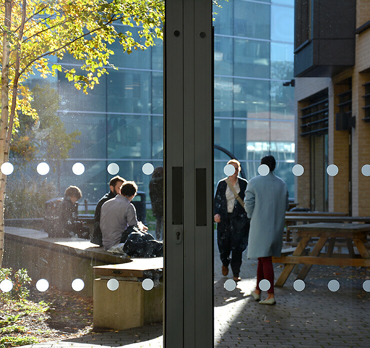 People sitting and walking in the garden of the Alison Richard Building.