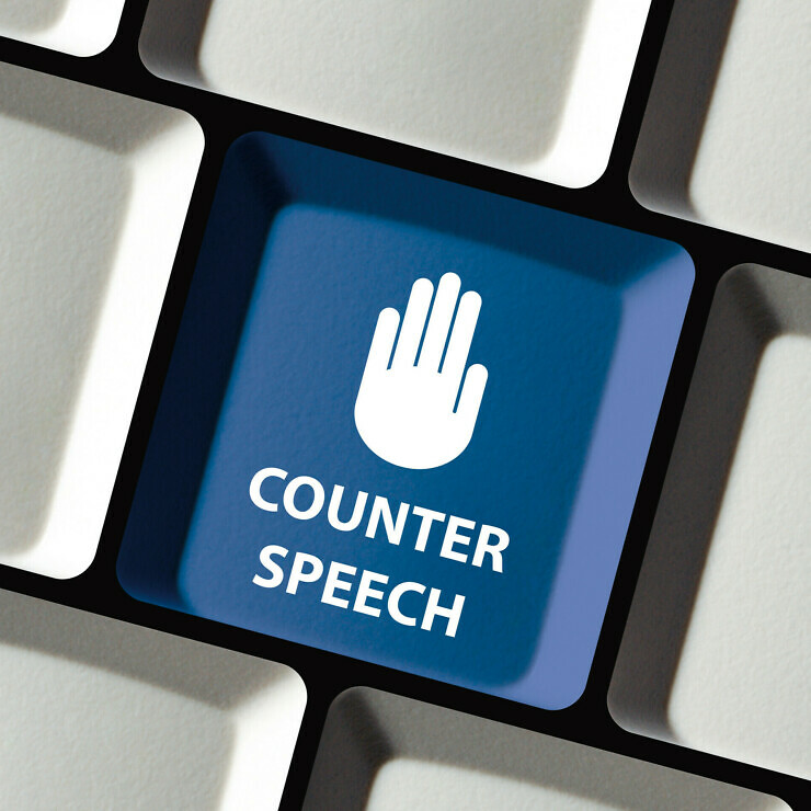 Computer keyboard key with the an raised hand symbol and the words Counter speech