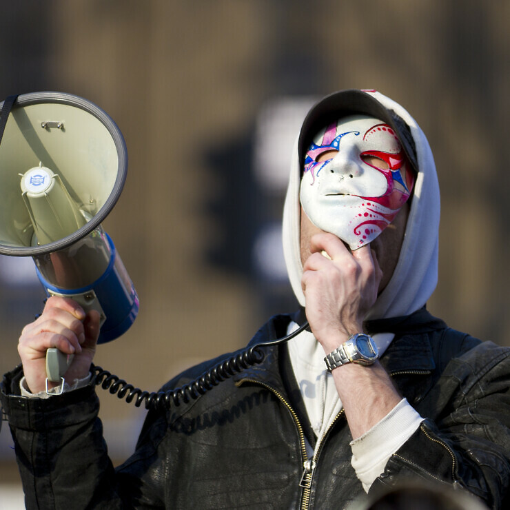 Masked man with a megaphone.