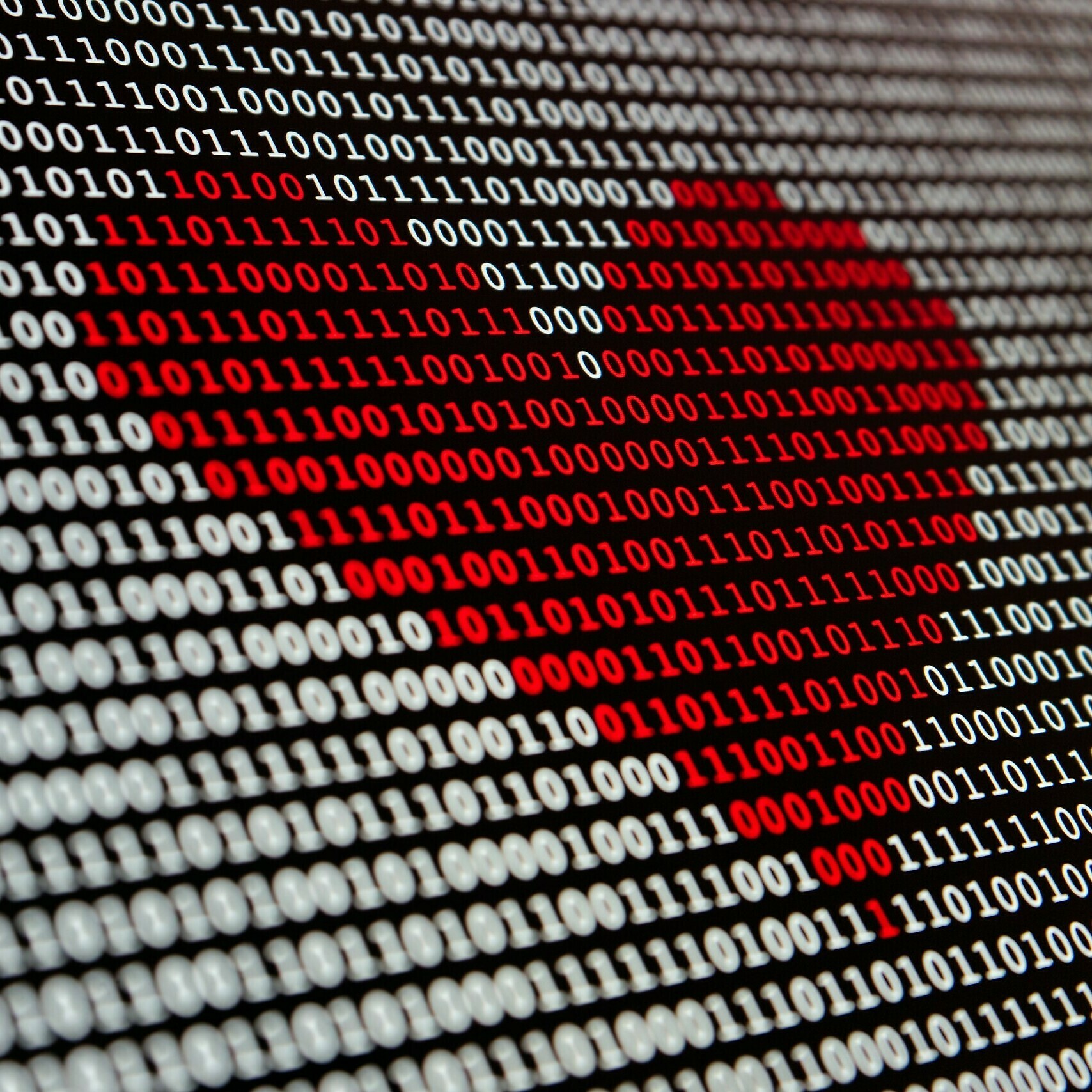A red heart on a screen made up from code.