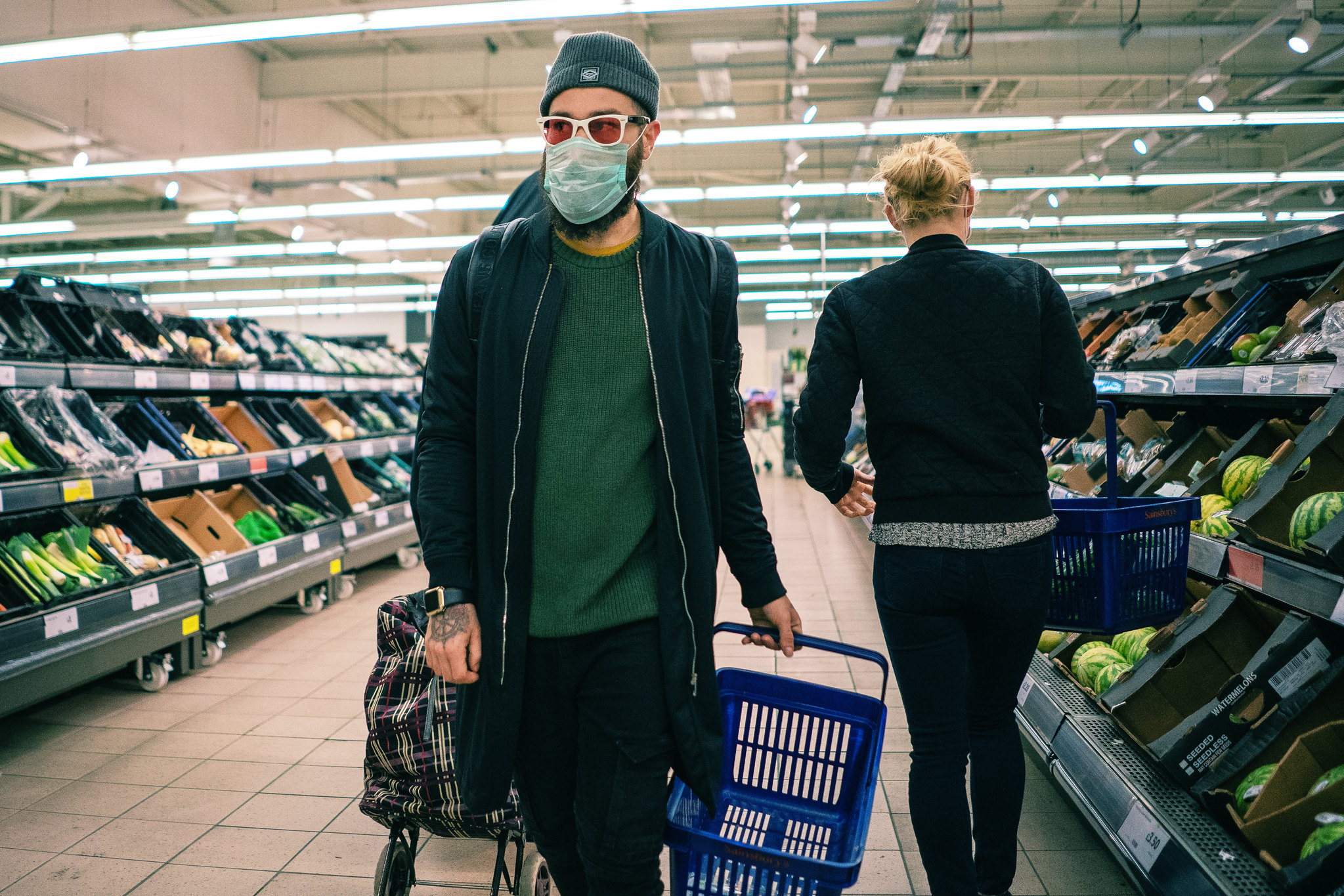 A man wearing a face covering shopping in a supermarket.