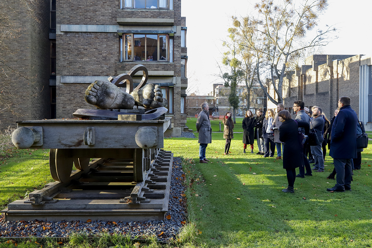 A group of people looking at an open air sculpture by Eduardo Paolozzi.