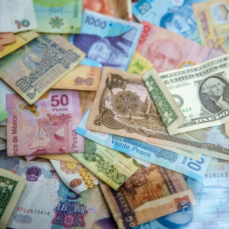 A pile of bank notes from many different countries.