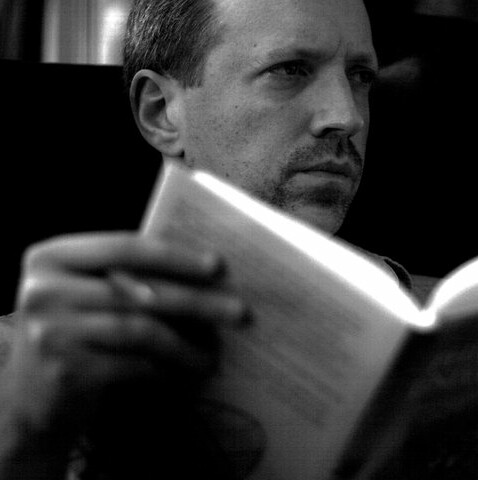 Portrait of Tom Angier reading a book.