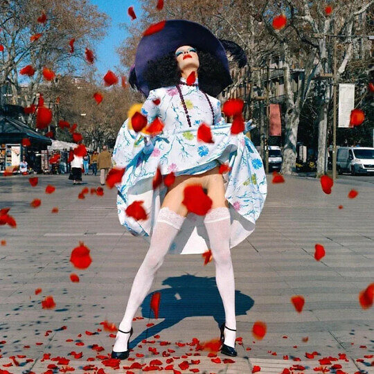Drag Queen Marina performing as Ocana among falling rose petals.