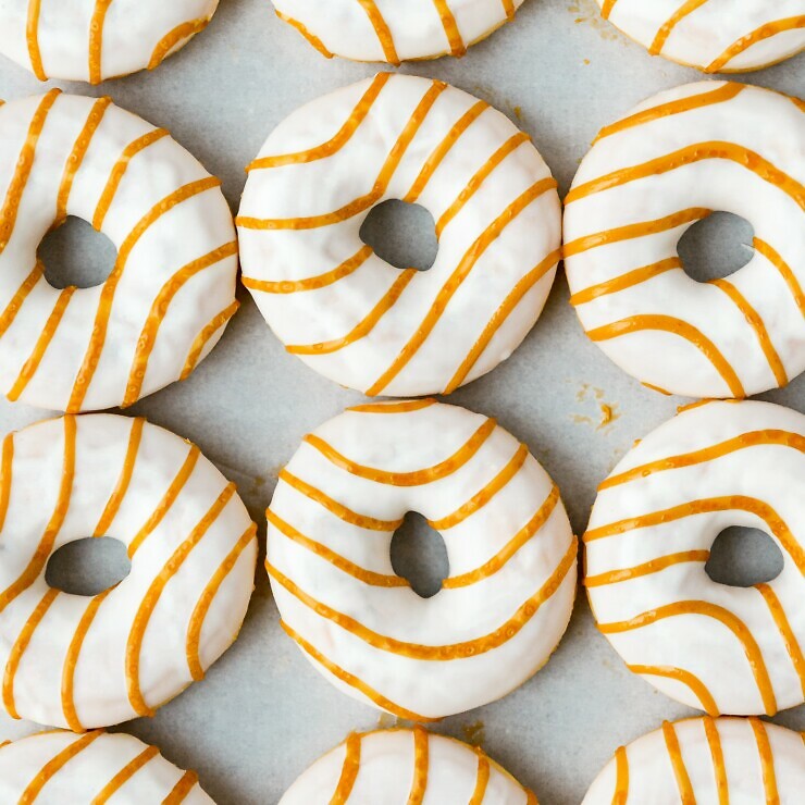 Doughnuts with white icing and orange wavy lines