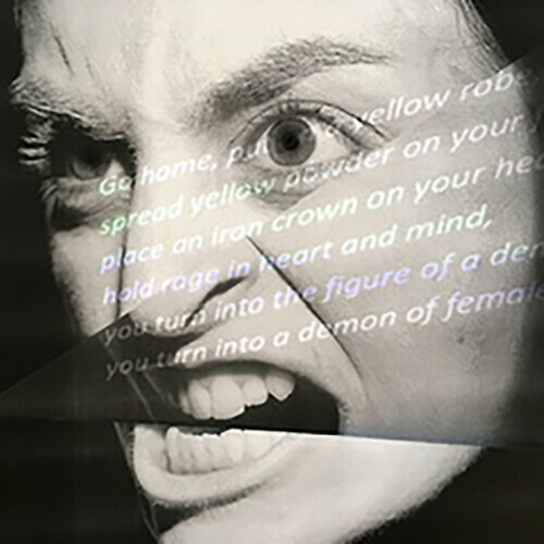 Black and white photograph of an angry face with text projected onto it. The text is not legible in the image.