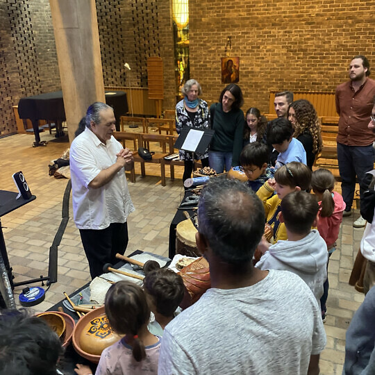 Christopher Garcia demonstrating instruments to a group