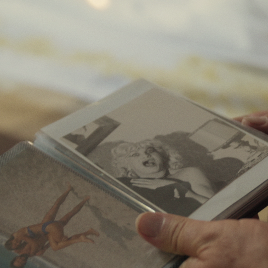 Film still from C'è un soffio di vita soltanto, a person is looking through a photo album.