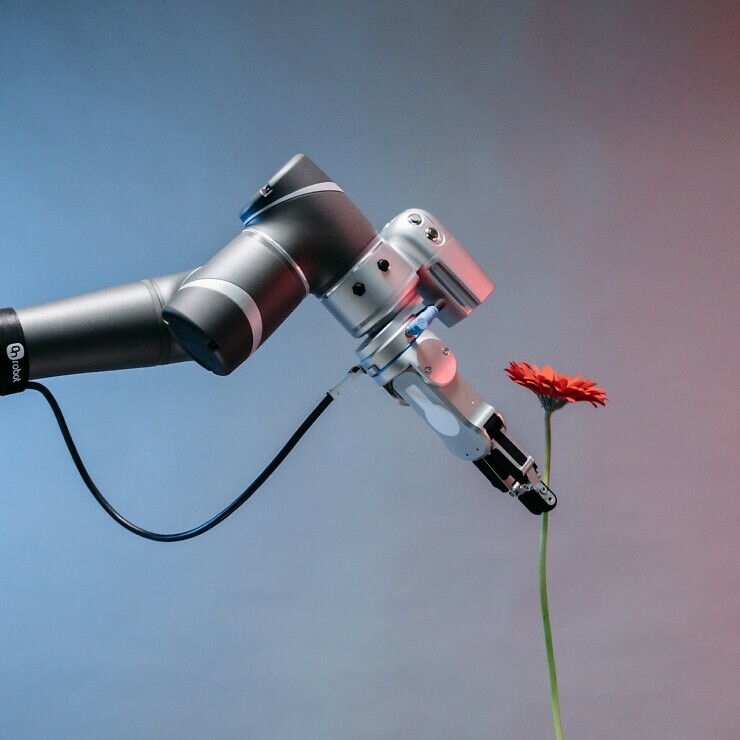 A robot arm delivering a flower.